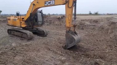 A Close-up of excavator bucket digs the ground