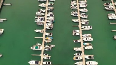 An aerial view of boats parked on a beach  inside the water with seascape on a sunny day