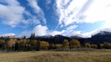 Time-lapse of the color autumn nature, blue sky with white clouds, color trees and mountains in the background