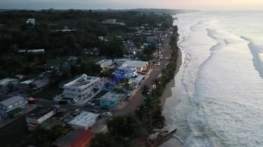 A drone shot over the buildings and the sea with beach of Coast of Aguada, Puerto Rico