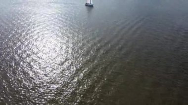 A sailboat on the Zegrzynskie lake, so much water and a forest on the shore in the background, Poland