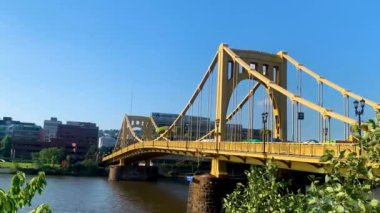 The blue sky over Andy Warhol Bridge seen from the Allegheny river waterfront with the Pittsburgh downtown in the background