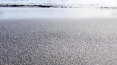 Sand beach with waves in the background, low point of view