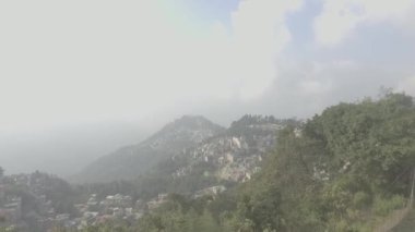 An aerial view of houses in the mountains on a cloudy day