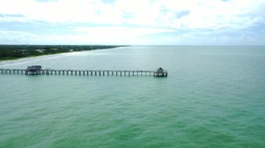A beautiful HD footage of a long bridge in the clam sea at Naples Beach Fiori on a sunny day
