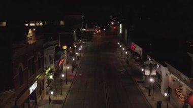 Sokak lambaları ve araba kullanan bir gece şehir manzaralı İHA görüntüsü.
