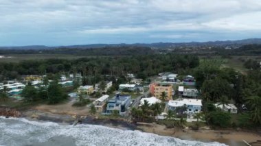 An aerial view of the coastal village of Aguada, Puerto Rico under a cloudy sky