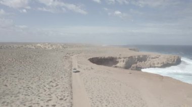 Batı Avustralya 'nın ücra köşesindeki uçurumlar boyunca giden bir araba okyanusun çölle buluştuğu yerde.