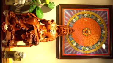 A closeup view of a small statue of Buddha on the table with decorations