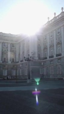 A vertical footage of the Royal Palace of Madrid with a sun flare behind in Spain