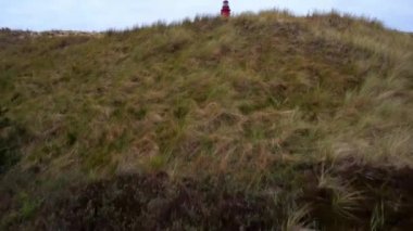 Revealing Shot over dunes of a Lighthouse