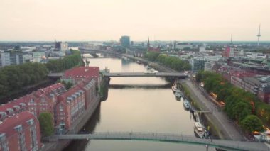 An aerial shot of a river flowing through the city of Bremen, Germany