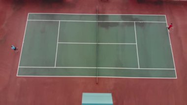An aerial view of a father and son playing tennis on a court in Leander, Texas