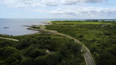 Static drone aerial looking down ocean Ave Newport Aquidneck Island Rhode Island. 2 bicycles riding away.