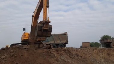 Hindistan 'da işlevsel bir kazıcı kullanarak kum çalmak.