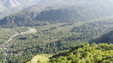 A downhill view of lush green valleys between mountain forests