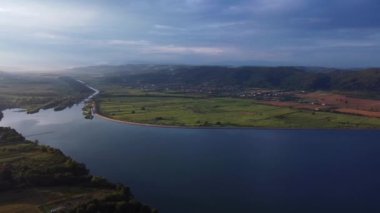 A scenic view of a lake landscape under a dark cloudy sky