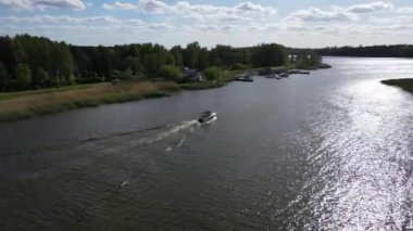 A boat going through Zegrzynskie lake near green forests