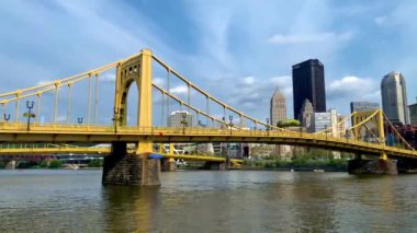 The cloudy blue sky over Andy Warhol Bridge seen from the Allegheny river waterfront with the Pittsburgh downtown in the background