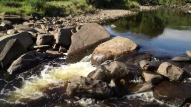 A beautiful view of a river flowing past and over rocks in Dunbeath Strath, Scottish Highlands