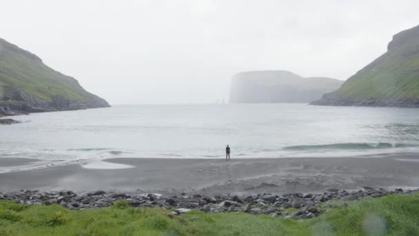 デンマークのフェロー諸島で雨の日に水の体の海岸に立つ者 — ストック動画