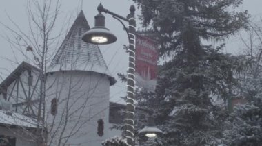 A beautiful view of a street lamp post with buildings in the background on a cold winter day