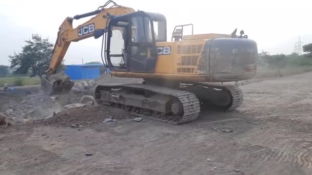 地球移動装置だ 黄色い掘削機が地面を掘ってる 掘削機のバケツが建設現場の大きな岩をすくい取る — ストック動画
