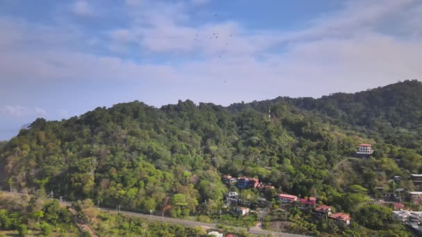 Drone Shot Lush Forested Green Mountains Houses Blue Cloudy Sky — Stockvideo
