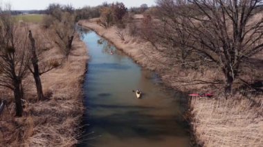 An aerial drone footage of a person in a paddling gliding on the polluted river in Brandenburg, Germany