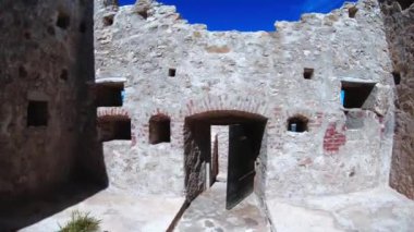 A beautiful view inside an old ancient ruins of a castle in the ocean with bridge in the background