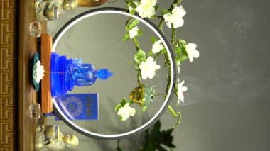 A closeup view of a small statue of Buddha on the table with decorations