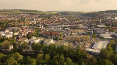 A drone shot over a cityscape of Bad Mergentheim with trees and green landscape on a sunny day