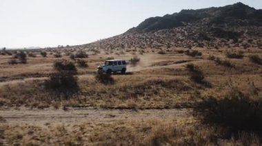 An aerial view of Mercedes Benz G Wagon driving through a desert in Palmdale, California