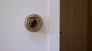 A closeup of an vintage light switch on a white wall
