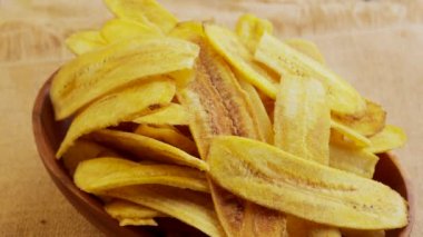 A closeup of a bowl of banana chips rotating on a lazy Susan