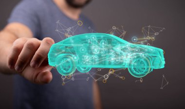 Bir adamın eli, otonom bir elektrikli arabanın hologramını işaret ediyor.