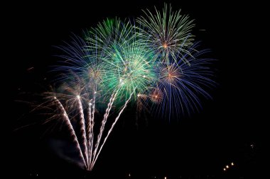 Gece gökyüzündeki parlak renkli havai fişekler.