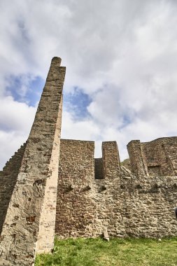 A vertical shot of the Ruins of the Lowenburg castle in Monreal Eifel in Germany with a blue cloudy sky