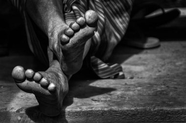 Bulanık bir arka planı olan birinin çıplak ayaklarının tek renkli, yakın plan çekimi.