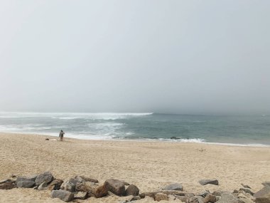 Sis altında dinlenen insanların olduğu güzel bir sahil.