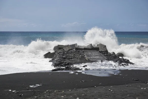 岩の多い海岸を襲う泡の波の接近ショット — ストック写真