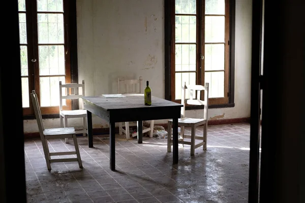 An old abandoned dining room with wooden furniture and windows