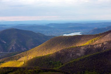 a patch of light over the hills, clouds, sunlight