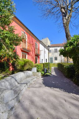 Nusco İtalya 'da küçük bir köyde mavi gökyüzünün altında evleri olan dar tuğladan bir sokak.