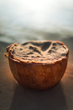 A vertical shot of a coconut shell with sand on a beach in Boracay, Phillippines