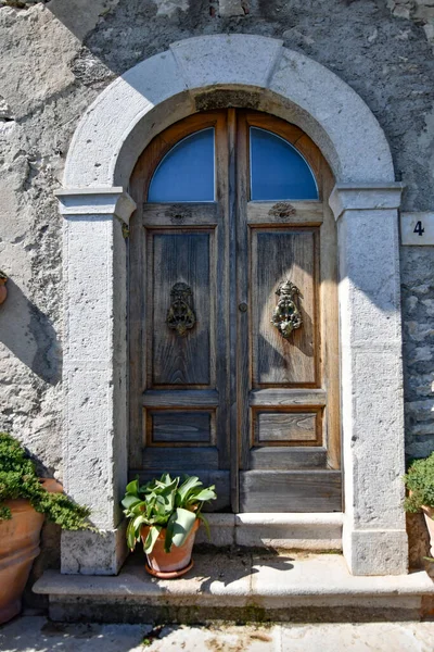 İtalya 'nın Campania bölgesindeki Morcone kasabasındaki eski bir ahşap kapının dikey görüntüsü.