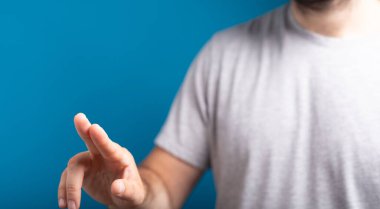 Mavi arkaplanı olan boş bir dijital ekrana tıklayan bir Erkek el