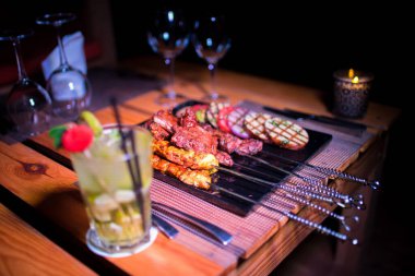 Bir tabak tavuk ve sığır barbeküsü yanında da bir bardak taze mojito.