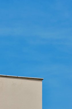 Güneşli bir günde mavi gökyüzüne karşı beyaz bir duvarın ayrıntıları.