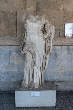 A vertical shot of a headless sculpture near a building, Athens, Greece